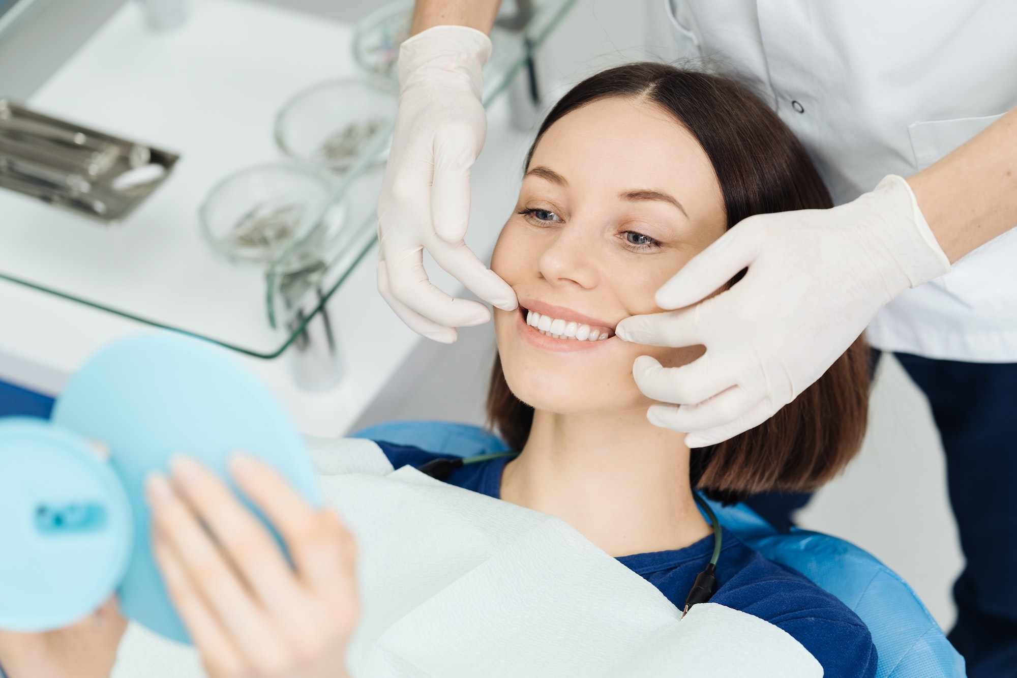 Perfect smile, woman looking in the mirror. Visit at the dentist